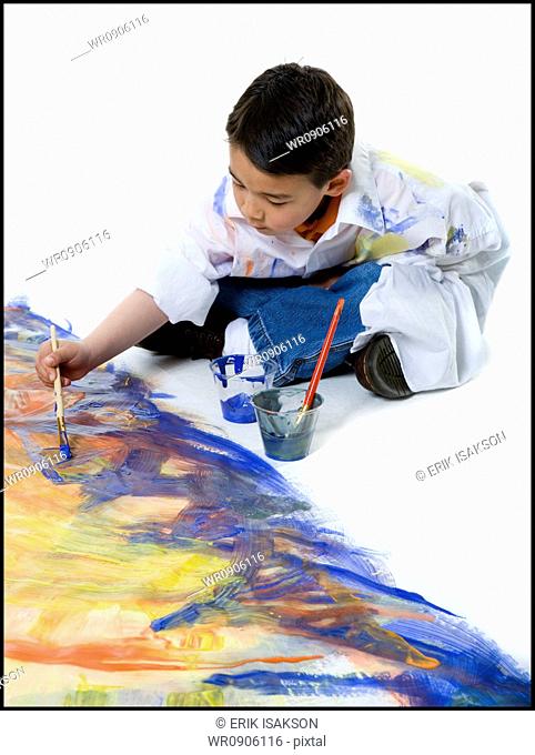 High angle view of a boy painting on the floor