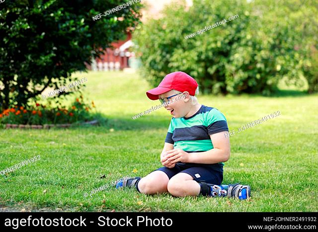 Happy boy sitting in garden