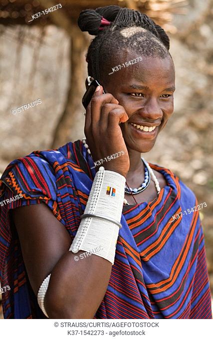Maasai man wearing traditional dress and using modern smart phone