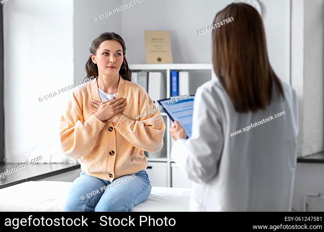 doctor with clipboard and woman at hospital