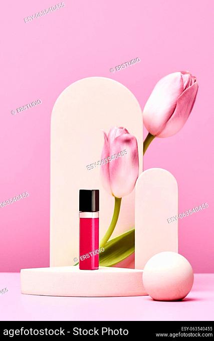 lip gloss on podium with pink tulips and elegant arch on pastel pink background. minimal fashion design. mock up