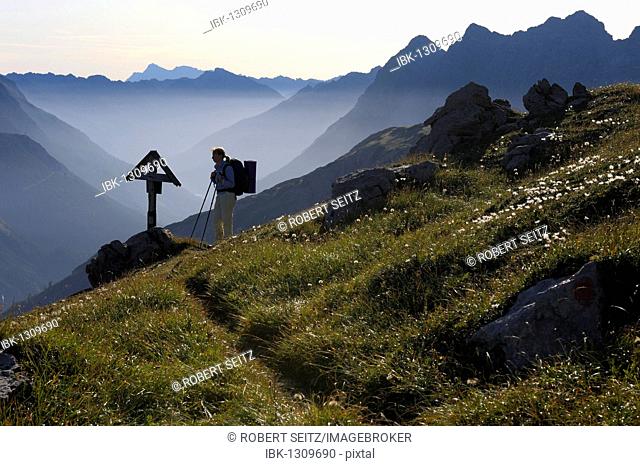 Mountaineer in front of memorial cross in the morning light, Hinterhornbach, Lechtal, Ausserfern, Tyrol, Austria, Europe