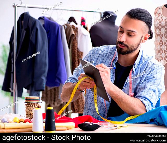 The male tailor working in the workshop on new designs