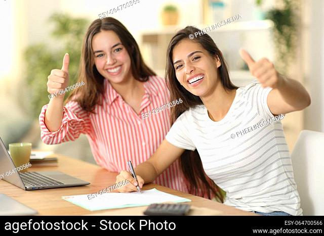 Happy roommates signing form with thumbs up at home