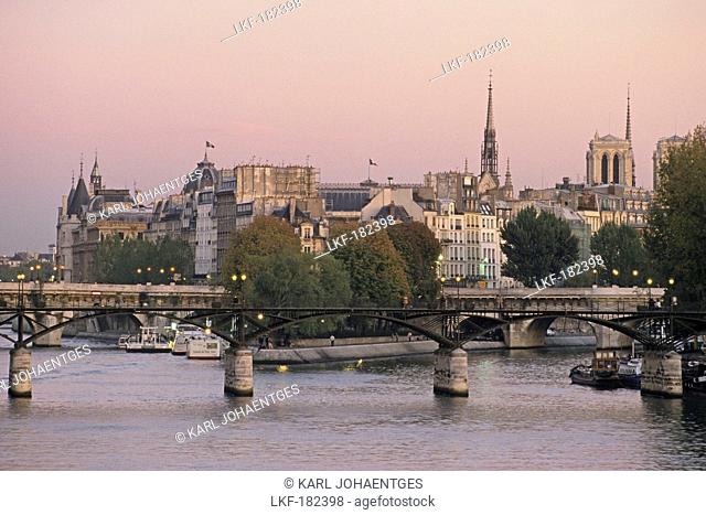 Iron bridge across the Seine river connecting Louvre and Institut Francais, Les Passerelles des Arts, Ile de la Cite in the background, 1