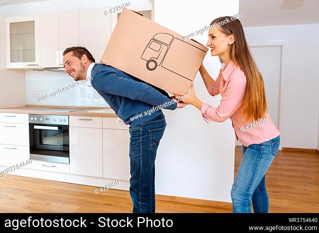 Woman giving her man a moving box in the new home