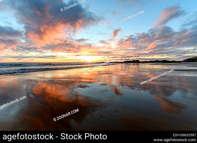 Sunset at the atlantic Ocean with orange beach and sky in France