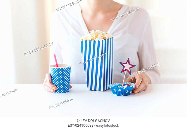american independence day, celebration, patriotism and holidays concept - close up of woman eating popcorn with drink and candies at 4th july party