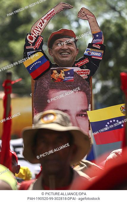 20 May 2019, Venezuela, Caracas: Supporters of Venezuelan President Nicolas Maduro wear a portrait of the head of state (below) and his predecessor Hugo Chavez...
