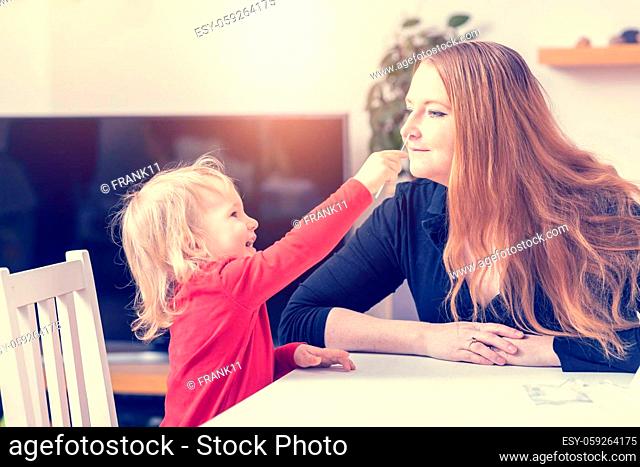 Laughing cute little boy puts a swab in his mother's nose. Using antigen self-using kits concept