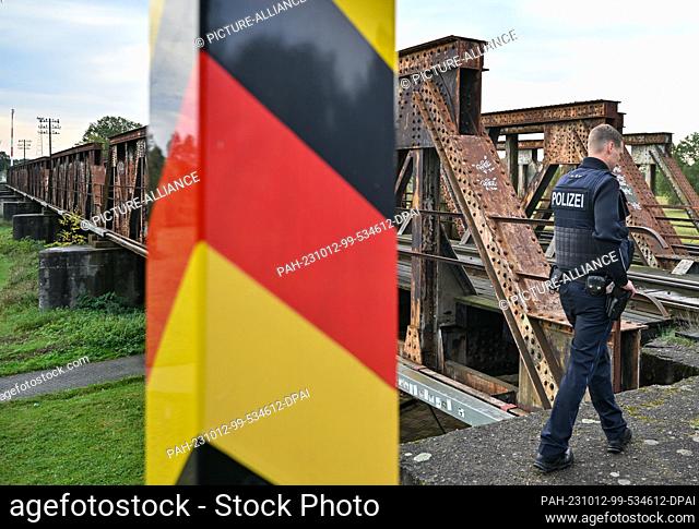 11 October 2023, Brandenburg, Forst: A federal police officer stands at a railroad bridge over the Neisse River, the German-Polish border in Forst (Lausitz)