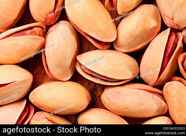 Tabletop view, closeup of turkish red pistachios on wooden board
