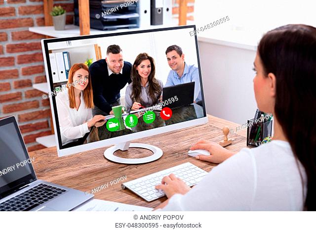 Side View Of A Young Businesswoman Videoconferencing With Her Colleagues On Computer