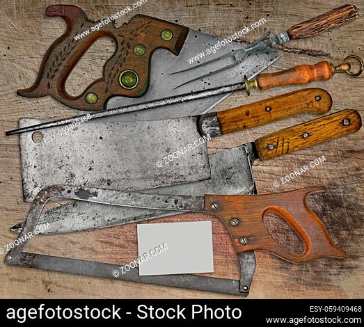 vintage butcher shop tools over stained wooden table, space on business card for your text
