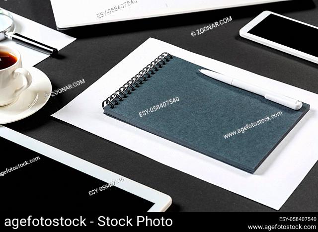Top view of designer workplace with modern digital devices. Flat lay contemporary design with black surface. Digital technology and mobile lifestyle