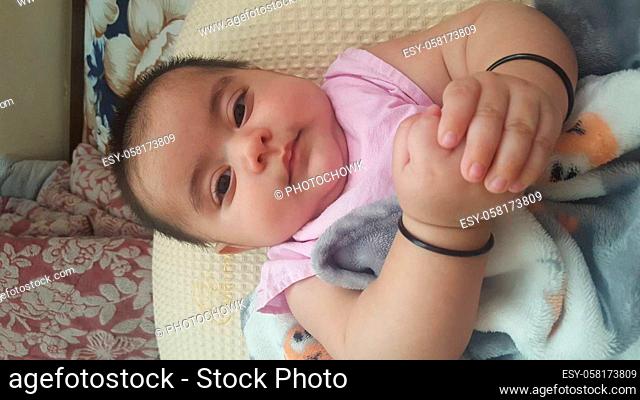 Baby girl with lovely face, big eyes and cute face gesture. Toddler baby making sweet activities