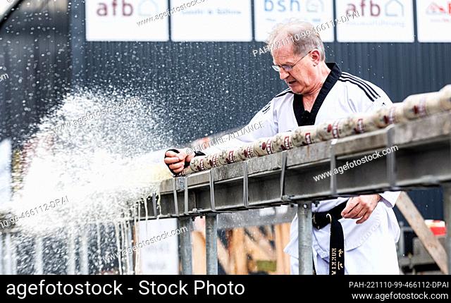 10 November 2022, Hamburg: Muhamed Kahrimanovic smashes 53 filled beer cans with a raw egg in his striking hand in 30 seconds at an event organized by the...