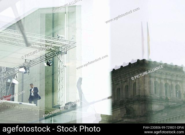 06 August 2023, Berlin: Markus Söder (CSU), federal chairman of his party, walks next to a reflection of the Reichstag building to his place just before...