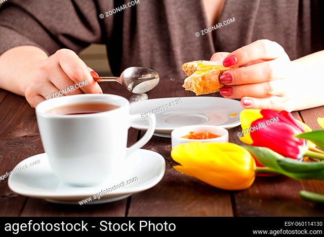 Breakfast concept. Woman eat bread and jam and drinking tea