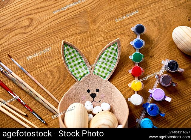 Top view pack of eggs with brush, paint and decorative elements on wooden background. Copy space, Happy Easter, DIY, flat lay