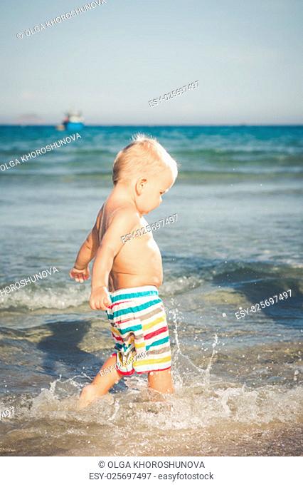 Cute baby plays in a sea