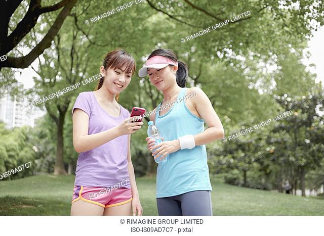 Female friends looking at cellphone in park