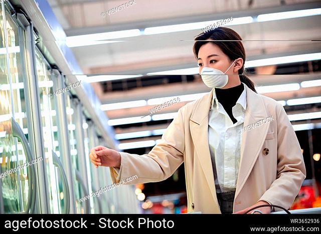 Wearing a mask of young women shopping in the supermarket