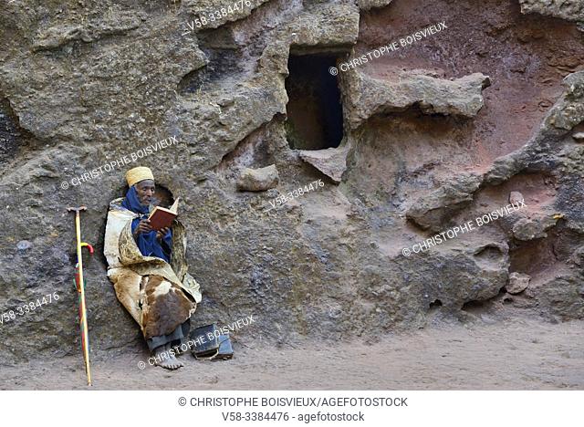 Ethiopia, Lalibela, World Heritage Site, Rock-hewn church of Bieta Giyorgis (12-13th C), Hermit wrapped in cow skin reading the bible