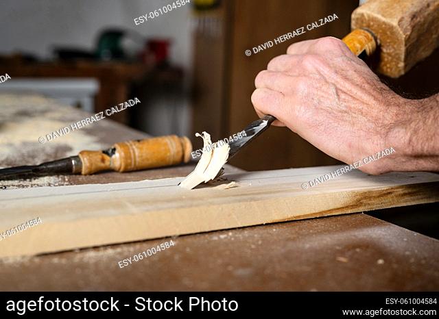 Close up of a Carpenter carving wood with chisel . High quality photography