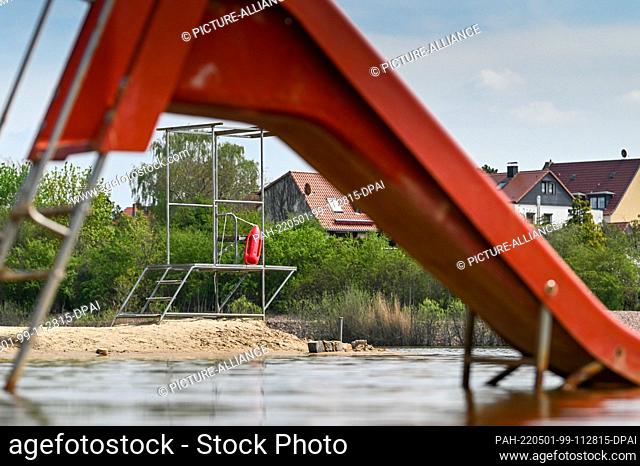 29 April 2022, Saxony-Anhalt, Halle (Saale): The water slide and the watchtower for the swimming master at the Heidesee outdoor pool in Halle