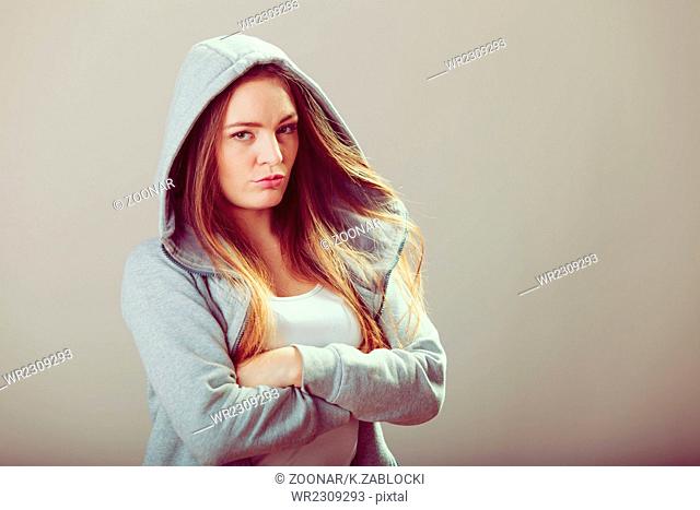 Pensive teenager girl in hood crossing arms