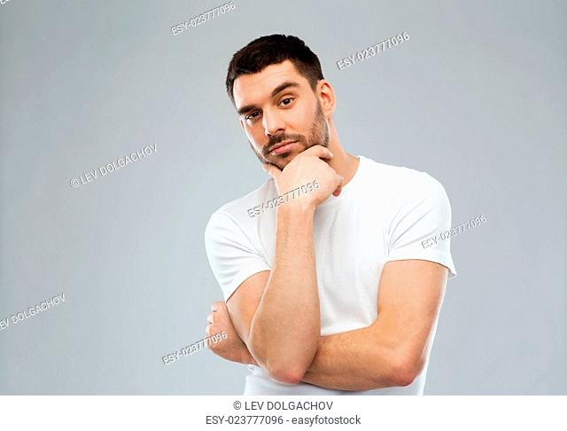 doubt, expression and people concept - man thinking over gray background