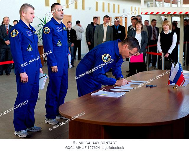 Expedition 31 NASA backup crew member Kevin Ford signs for his International Space Station Russian segment event simulation test card before senior officials at...