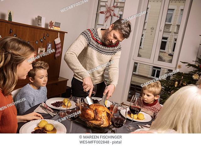 Father cutting the turkey during Christmas dinner