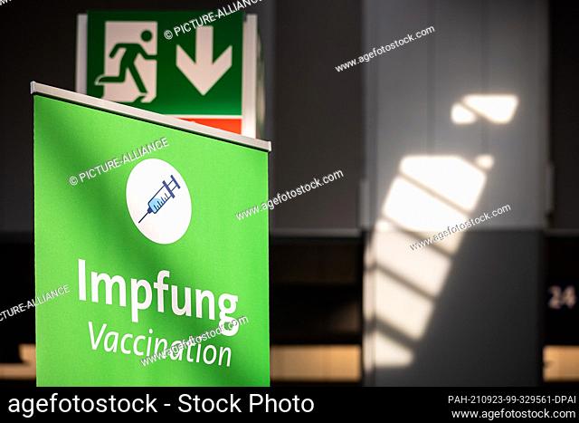 23 September 2021, Lower Saxony, Hanover: The lettering ""Impfung - Vaccination"" can be read under an ""emergency exit"" pictogram at the vaccination centre on...