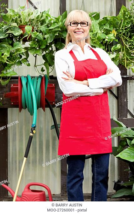 Portrait of a senior gardener with arms crossed in greenhouse