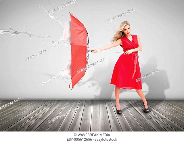 Attractive woman holding an umbrella to protect herself from the rain