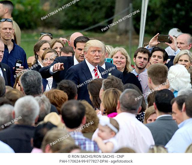 United States President Donald J. Trump is surrounded by guests as he prepares to work the rope line as he and first lady Melania Trump host the annual...