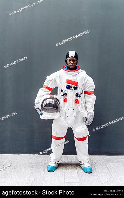 Male astronaut standing in front of gray wall