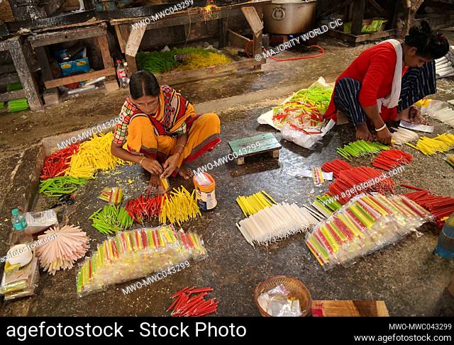 Women making colourful candles at a factory ahead of the Diwali festival at Agartala. Agartala, Tripura. India
