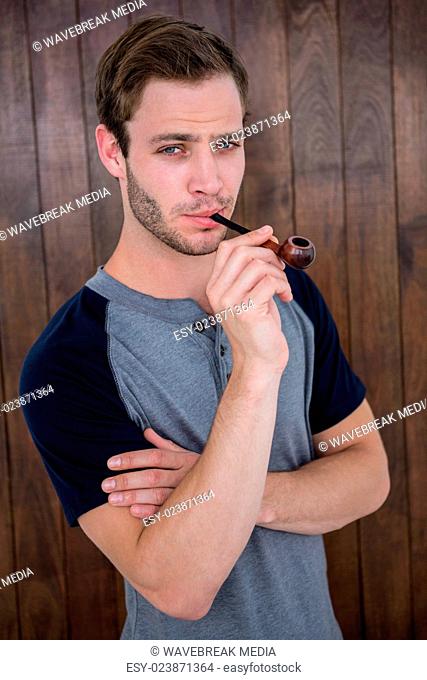 Handsome hipster smoking pipe