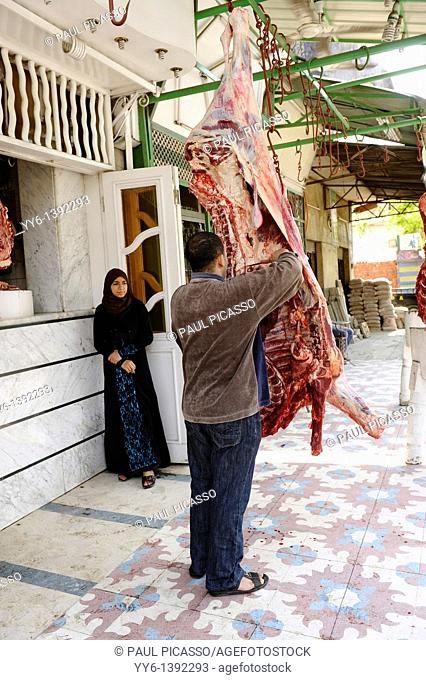 young muslim lady buying beef from street butcher , souk goma friday market , street market , Southern Cemeteries , Khalifa district , cairo