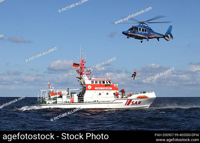 07 September 2020, Mecklenburg-Western Pomerania, Warnemünde: A helicopter picks up a person from the rescue cruiser Theo Fischer during a rescue exercise on...
