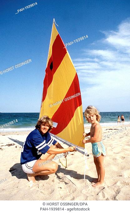 Wayne Carpendale helps his father to set a small sail on beach, pictured in 1979. By now the son of Howard Carpendale is a handsome young man of 22 and appears...