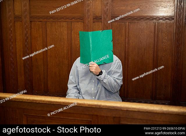 12 December 2023, Berlin: A 39-year-old defendant sits in Berlin district court and hides his face. Around seven months after the knife attack on two girls in a...