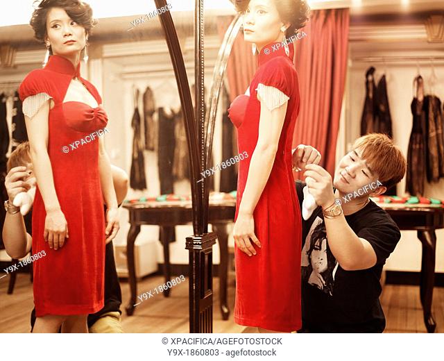 Fashion designer, Lu Kun fitting a traditional qipao inspired modern dress on a model