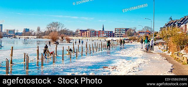 Wagenignen, The Netherlands - February 13, 2021: Ice skating on frozen street and floodplains along river Rhine in Holland