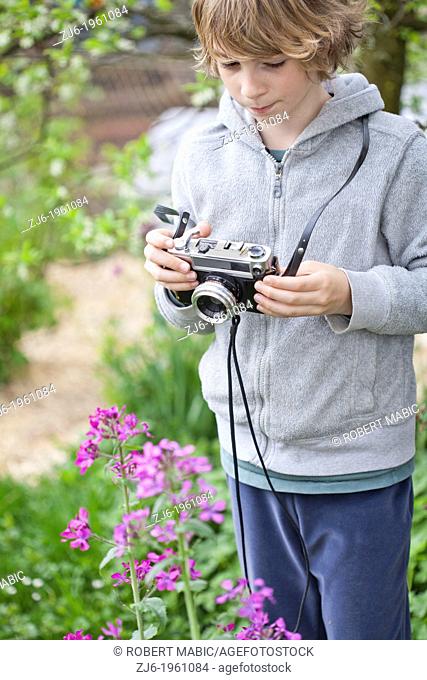 Boy photographing flowers in the garden