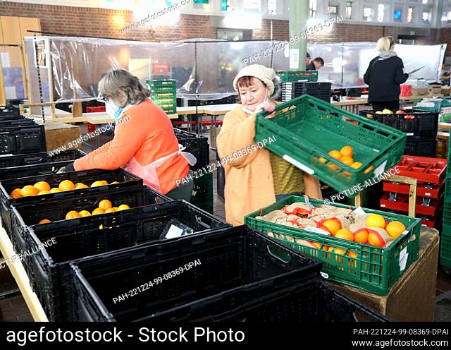 13 December 2022, North Rhine-Westphalia, Oberhausen: Employees of the Oberhausen food bank sort fruit and vegetables for their customers in the nave of a...