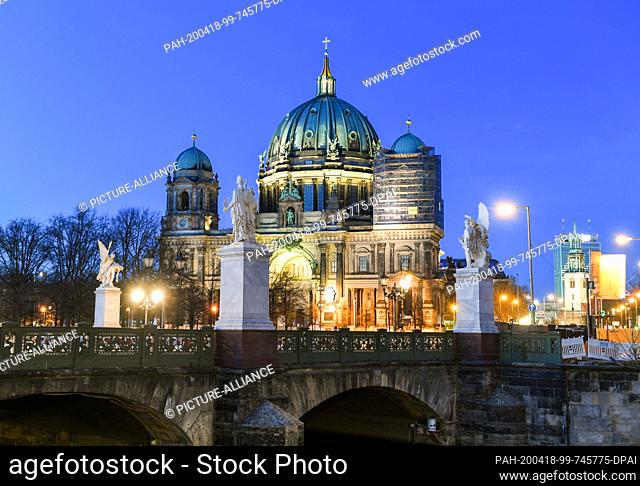 10 April 2020, Berlin: The Berlin Cathedral at the Lustgarten in the evening at the blue hour. In the foreground the Schlossbrücke
